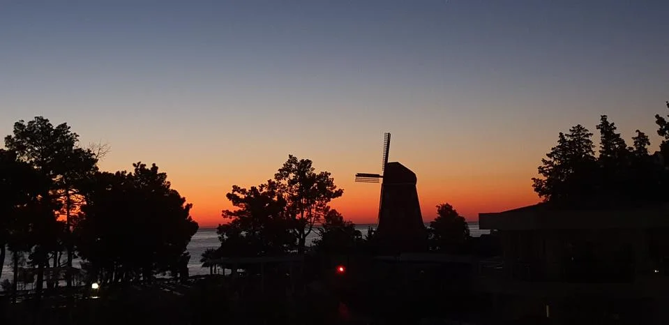 Silhouette of a windmill at sunset Stock Photos