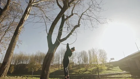 Silhouette of woman doing some acrobatic elements on aerial hoop outdoors Stock Footage 101852912