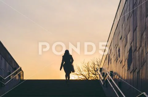 Silhouette of a woman emerging from an underpass. City life Stock Photos