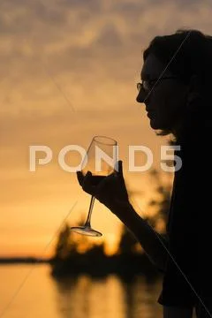 Silhouette Of Woman Holding A Wineglass, Lake Of The Woods, Ontario, Canada