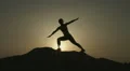 Silhouette of woman practicing yoga alone on top of mountain in the evening HD Footage