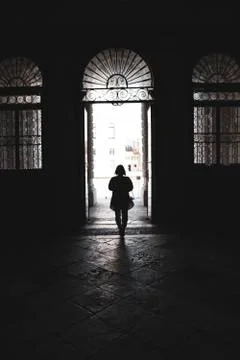 Silhouette of a woman walking through an arched doorway in Venice, Veneto, Stock Photos