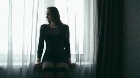 Silhouette of woman in window. Loop Stock Footage 86907542