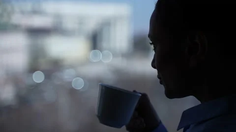 Silhouette of woman's face drinking tea by window Видео 151895628