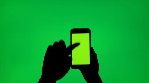 Silhouette of a woman's hand making swipe up gesture with a mobile phone Stock Footage 92201284