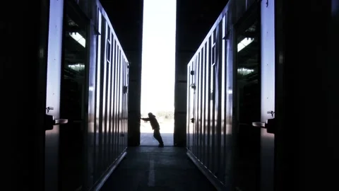 Silhouette of Worker Opening Large Industrial Metal Doors Stock Footage 107177675