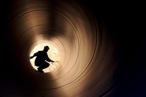 A silhouette of a worker in pipe Stock Photos