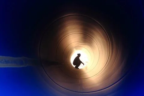 A silhouette of a worker in pipe Stock Photos