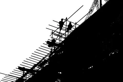 Silhouette workers constructing building at the construction site. Stock Photos
