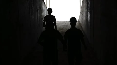 In silhouette workers working in a mine and wearing helmets Stock Footage 168945604