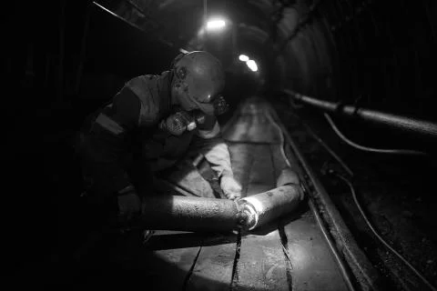 Silhouette of a working miner in a mine Stock Photos