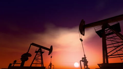 Silhouette of working oil pump jacks against a dramatic beautiful sunset sky. Vidéo 330852085