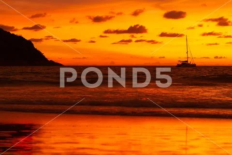 Silhouette of yacht on gorgeous sunset background. Nai Harn beach. Phuket isl Stock Photos