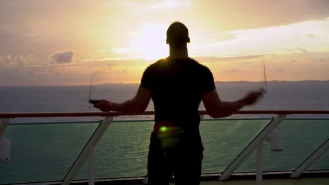 Silhouette of young athletic guy jumps on a rope during sunrise Stock Footage 109048461