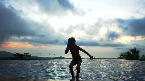 Silhouette of young boy jumping in the pool in slow motion. 1920x1080 Stock-Footage 83154327