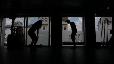 Silhouette of young couple doing exercises with jumping ropes Stock Footage 114086762