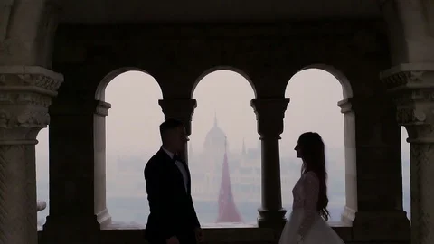 Silhouette of young couple on window background of arches of old building Stock Footage 129559623