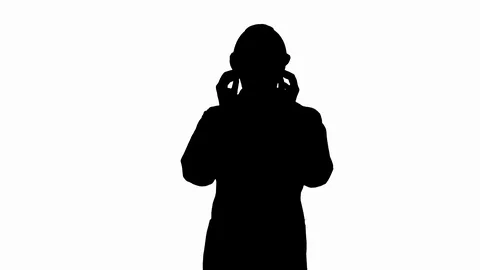 Silhouette Young engineer in robe and helmet putting glasses on while walking. Stock-Footage 108266855