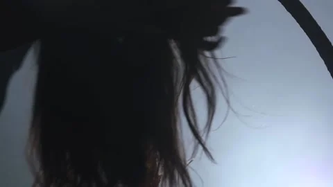Silhouette Young girl performs the acrobatic elements in the air ring. Slow Stock Footage 110664347