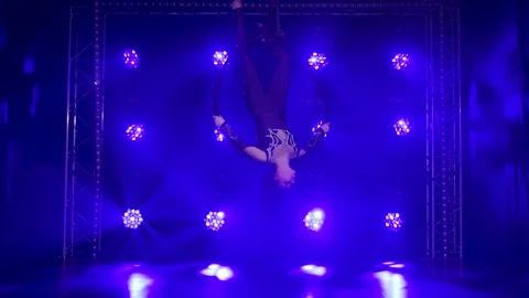 Silhouette young girl performs the acrobatic elements in the air ring. Shot in a Stock Footage 138368928