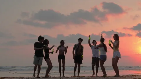 Silhouette of Young group dancing and drinking on the beach summer and sunset. Stock Footage 184301933