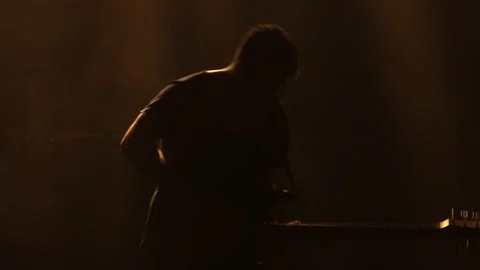 Silhouette of the young guy playing the electric guitar on stage in a dark Stock Footage 136490113