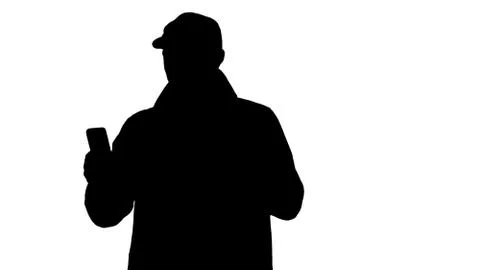 Silhouette Young man making a video call from his mobile phone while walking. Illustrazione stock