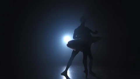Silhouette of young man practicing in classical ballet pirouette with ballerina Stock Footage 127588108