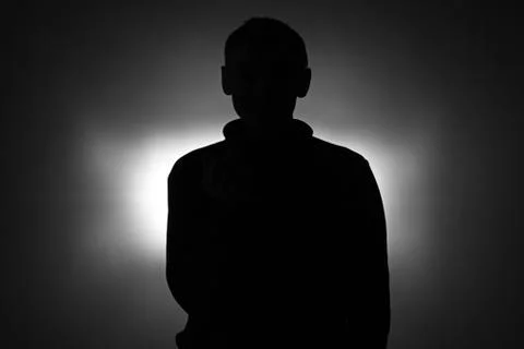 Silhouette of young man in pullover Stock Photos