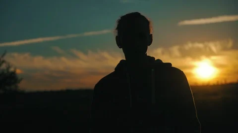 Silhouette of young man on sunset background outdoors, 4k Vidéo 98213801