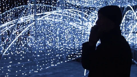 Silhouette of young man talking on cellphone in evening outdoors Stock Footage 83632038
