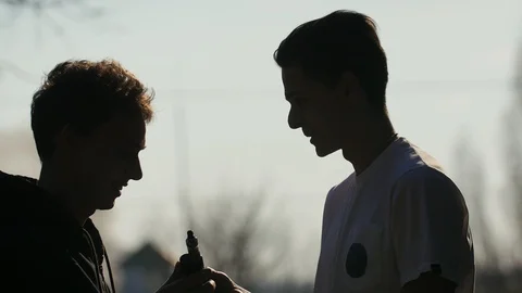 Silhouette of young man that throwing out cigarette from hand of his smoking Stock Footage 105081978