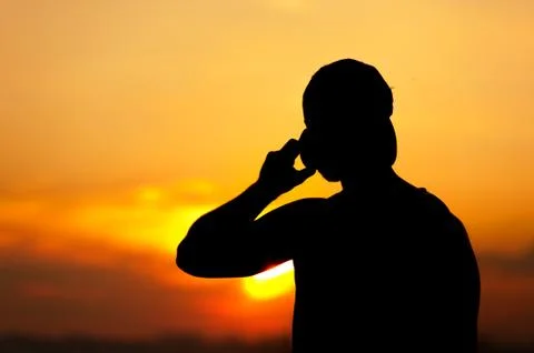 Silhouette of young man using his mobile phone Stock Photos