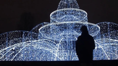 Silhouette of young man using smartphone standing alone outdoors at night Stock Footage 83631760