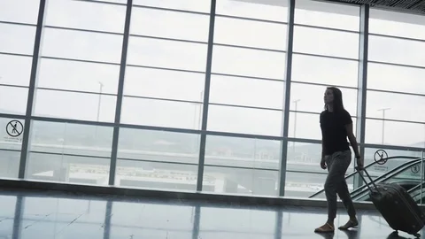 Silhouette of Young Pretty Business Woman Walking at Airport With Her Luggage Stock Footage