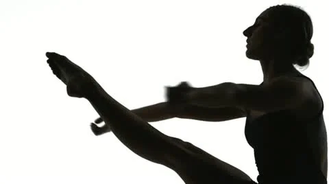 Silhouette of young woman dancing in front of white screen in slow motion Stock Footage