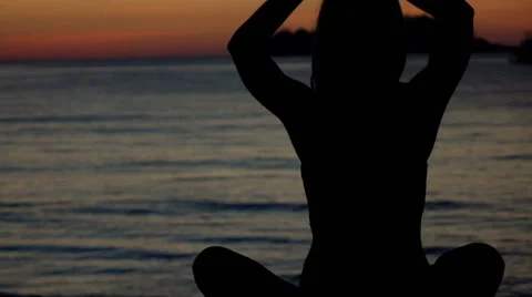 Silhouette of young woman meditating,on the beach during sunset, 240fps Stock Footage 59141535