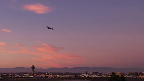 Silhouetted aircraft takes off over LAX California during a beautiful sunset Video stock 115075813