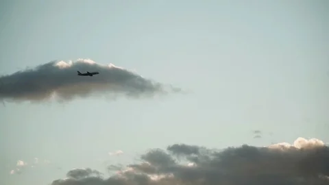 Silhouetted airplane flying up in the sky during the sunset Stock Footage 122621138