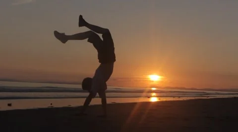 Silhouetted Boy Walks on Hands on Beach Stock Footage 47001384