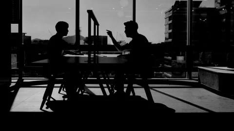 Silhouetted Business Team Working at Table in Dark Office Stock-Footage 338045949