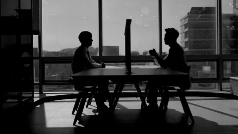 Silhouetted Businessmen Sitting at Table in Dark Office 스톡 동영상 338045849