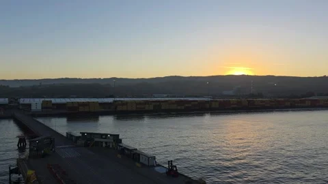 Silhouetted cargo containers ship loading pier sunset Coronel Chile Stock Footage 328695897