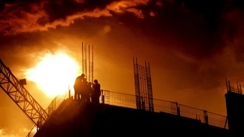 Silhouetted Construction Workers During a Vibrant Sunset Stock Footage 276294854