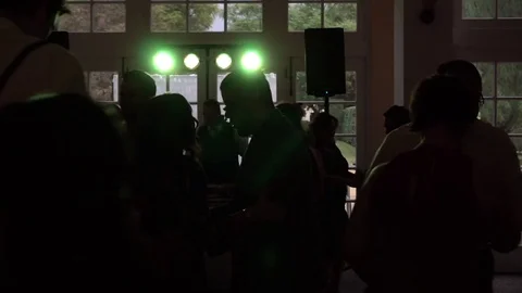 Silhouetted crowd dances while lights flash on dance floor Stock Footage 71252292