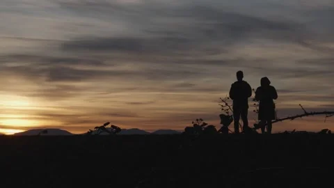 Silhouetted Cyclists at Sunset on Mountain Trail Video stock 268912923