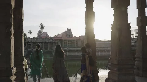 Silhouetted Devotees at Sacred Temple Tank Golden Backlit Cinematic Shot Stock Footage 338064715