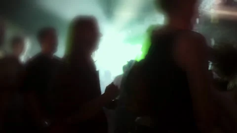 Silhouetted figures dancing in a vibrant atmosphere with colorful lights and Stock Footage 313637171