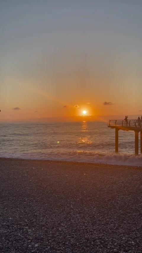 Silhouetted Figures Watching Dusk from Ocean Jetty Stock Footage 304884025