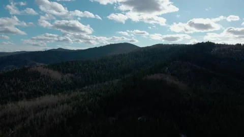 Silhouetted forested hills under dramatic cloudy sky at sunset Stock Footage 314030475